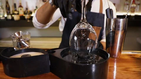 Bartender preparing a cocktail on a bar counter. Dipping the rims of a crysta Stock Footage 147680348