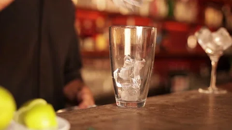 Bartender preparing cocktail by first squeezing fresh lime over ice Stock Footage 63306065