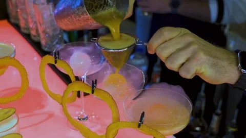 Bartender preparing cocktail with strainer and citrus garnish 스톡 동영상 314853963