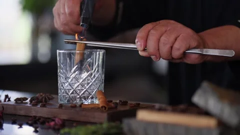 Bartender preparing a craft cocktail smoking cinnamon whiskey glass torch Stock Footage 288038701
