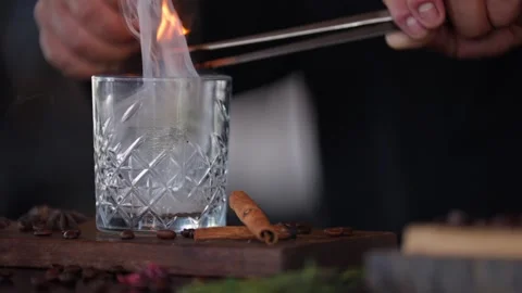 Bartender preparing a craft cocktail smoking cinnamon whiskey glass torch Stock Footage 288038702