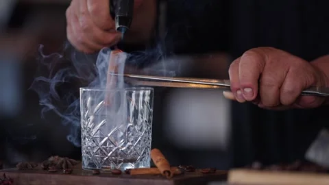 Bartender preparing a craft cocktail smoking cinnamon whiskey glass torch Stock Footage 288038703
