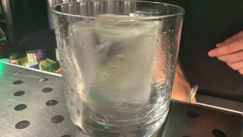 Bartender preparing a glass with ice in a modern bar Stock Footage 314131726
