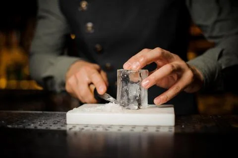 Bartender preparing a large rectangular piece of ice 库存照片