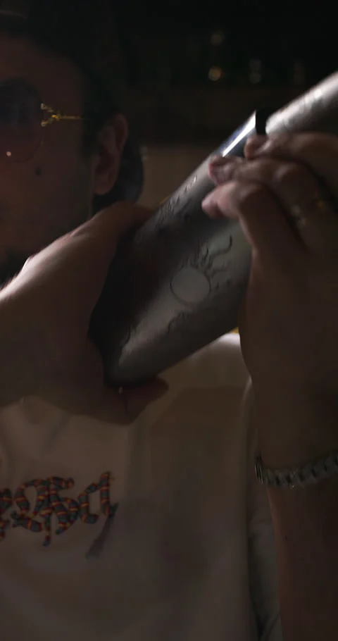 Bartender preparing mixed alcoholic drink, shaking a cocktail in a cocktail Stock Footage 312642421