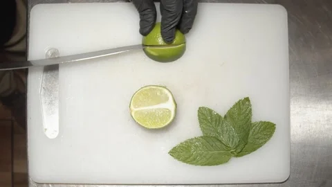 Bartender Preparing mojito cocktail with lime on ice. (C) Stock Footage 165464662
