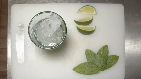 Bartender Preparing mojito cocktail with lime on ice. (B) Stock Footage 165464720
