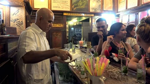 Bartender is preparing mojito in the 'La Bodeguita del Medio' bar.  Havana Stock Footage 235978747