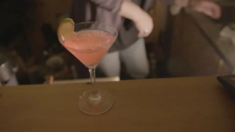 Bartender Preparing Pink Cocktail with Lime Garnish at Bar Counter in Beijing Stock Footage 345752414
