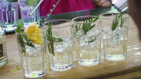 Bartender preparing, pouring refreshing alcohol drink with bubbles, ice, lemon Stock Footage 128818874