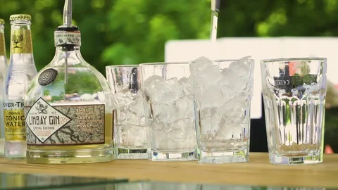 Bartender preparing, pouring refreshing alcohol drink with bubbles, ice, lemon Stock Footage 128818927