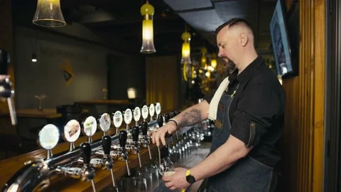 The bartender professionally pours beer on the general plan. Stock Footage 233614304