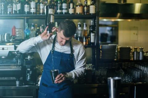 Bartender professionally working with om making drinks and cocktails Stock Photos
