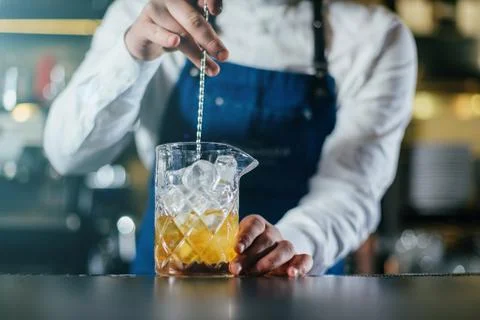 Bartender professionally working with om making drinks and cocktails Stock Photos