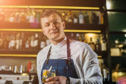 Bartender professionally working with om making drinks and cocktails Stock Photos
