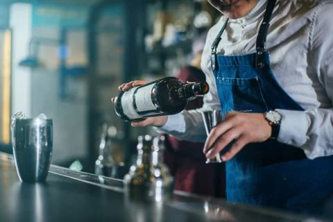 Bartender professionally working with om making drinks and cocktails Stock Photos