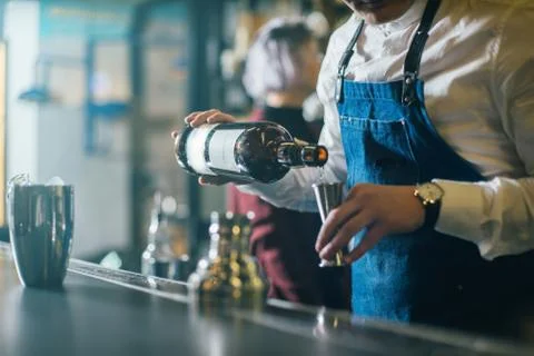 Bartender professionally working with om making drinks and cocktails Stock Photos