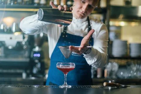 Bartender professionally working with om making drinks and cocktails Stock Photos
