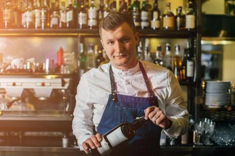 Bartender professionally working with om making drinks and cocktails Stock Photos