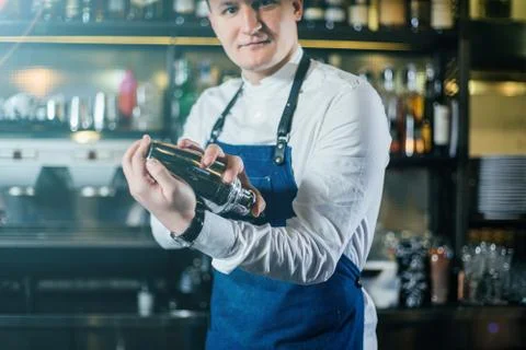 Bartender professionally working with shaker and making good drinks Stock Photos
