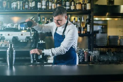 Bartender professionally working with shaker and making good drinks Stock Photos