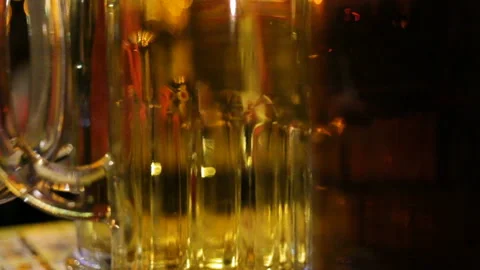 The bartender puts the beer glasses on the bar closeup, real-time, in the evenin Stock Footage 87425778