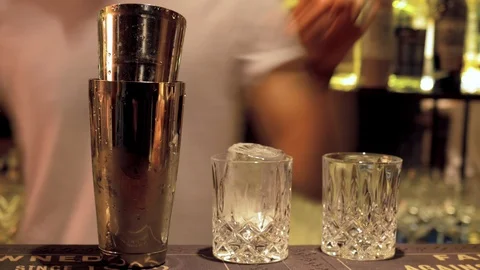Bartender puts big ice cube in glass with motion blur Stock Footage 118534758