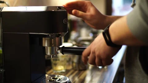 Bartender puts a cone with ground coffee into the coffee machine on the table Stock Footage 276450087