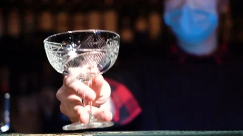 Bartender puts empty cocktail glass on bar counter 库存影片 149126317