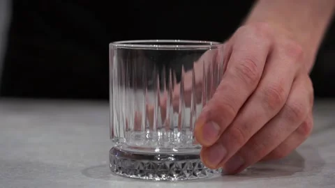 The bartender puts the glass on the table. Glass for alcohol. A man puts down a Stock Footage 219564352