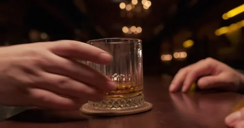 The bartender puts a glass of whiskey on the counter to the customer. Enjoy fine Stock Footage 258393198