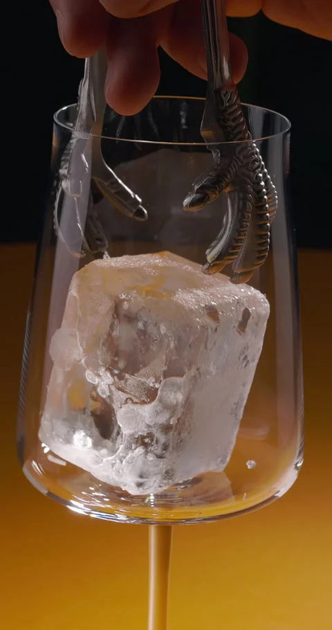 Bartender puts ice cube into a glass. Summer drink with alcohol, party, bar Stock Footage 309865527