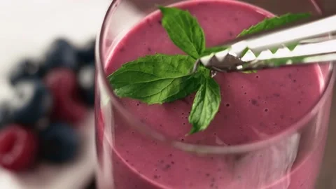 Bartender puts mint in a glass of berry smoothie. Healthy natural food. Stock Footage 138454231