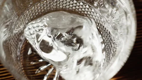Bartender puts a piece of ice in a glass, slow motion. Stock Footage 136545815