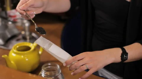 Bartender puts tea leaves into a tea bag. Medium shot Vidéo 63995287