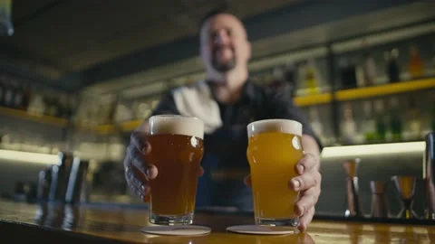 The bartender puts two glasses of beer on the bar counter. Stock Footage 234919824