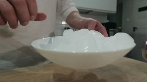 Bartender putting crystal ice cubes in shaker while preparing alcoholic cocktail Stock Footage 131546391