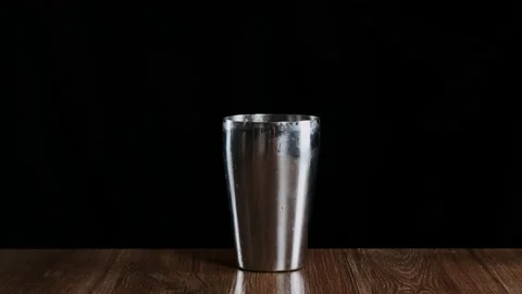 Bartender putting crystal ice cubes in shaker while preparing alcoholic cocktail Stock Footage 132765734