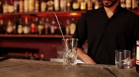 Bartender putting ice cube in mixing glass Stock Footage 63297748