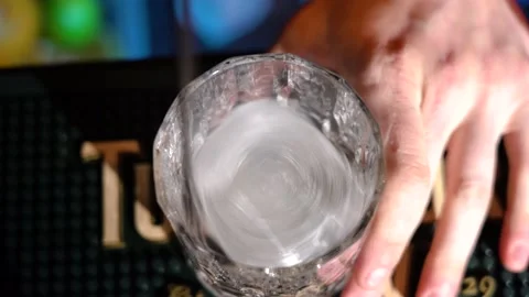 Bartender putting professional crystal ice cubes in glass preparing cocktail 库存影片 149240273