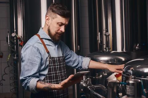 Bartender reads about the brewing processes. Stock Photos