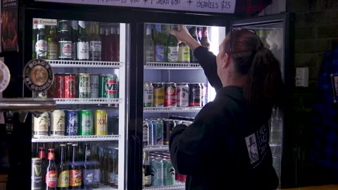 Bartender Selecting Beer From Commercial Drinks Fridge In Bar Stock Footage 340497825