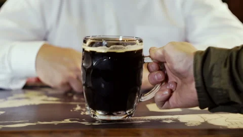 The bartender serves the man a mug of dark cold beer. Stock Footage 101751048