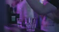 Bartender serving alcoholic drinks to clients at nightclub HD Footage
