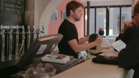 Bartender Serving Craft Beer To Clients Behind Counter Stockbeeldmateriaal 344303568