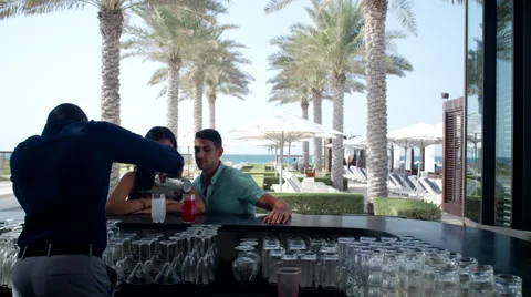 Bartender serving drinks to Expat couple at counter. Stock Footage 64110457