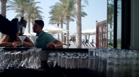 Bartender serving drinks to Expat couple at counter. Stock Footage 64110608