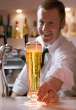Bartender serving a glass of beer Stock Photos