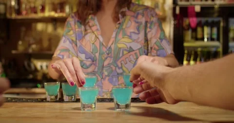 Bartender serving shots of blue alcochol Stock Footage 203899173