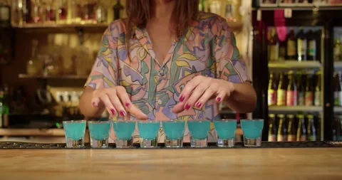 Bartender serving shots of blue liqour Stock Footage 203898936